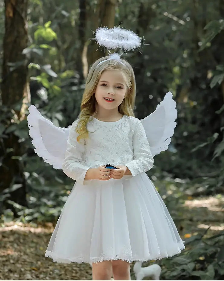Young girl in an angel costume with wings and a halo standing in a forest.