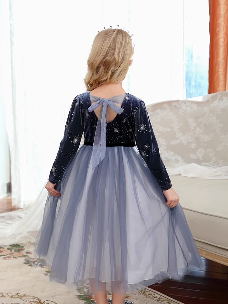 Child wearing a Dark Blue Long Sleeves Sparkle snow queen Princess Dress    with star patterns and a bow on the back, standing in a room.