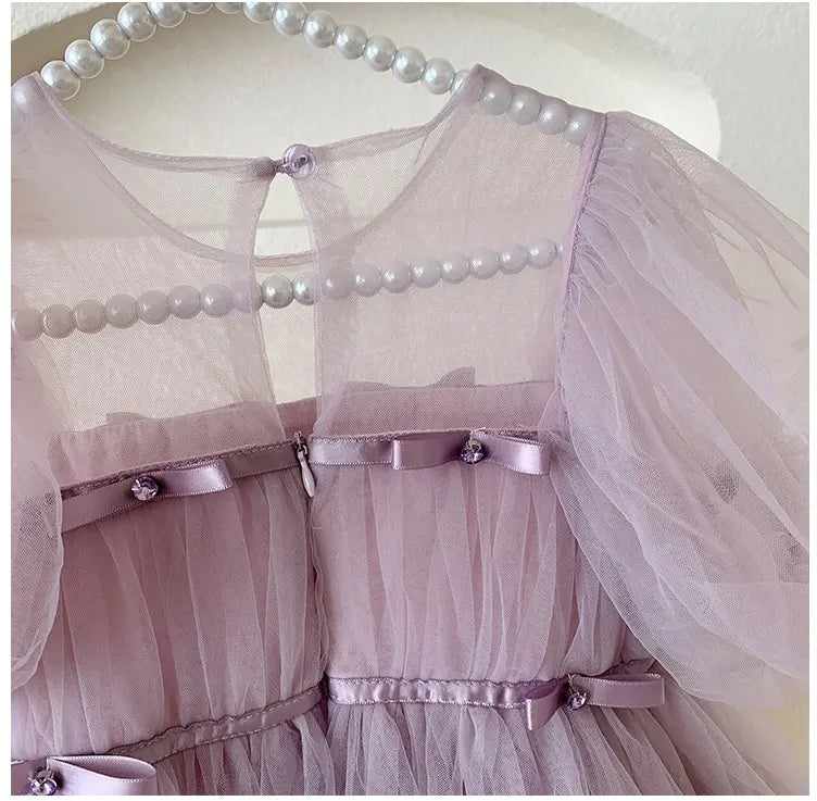 Close-up of a Purple Tulle Tutu Dress  with pearl embellishments on a white background