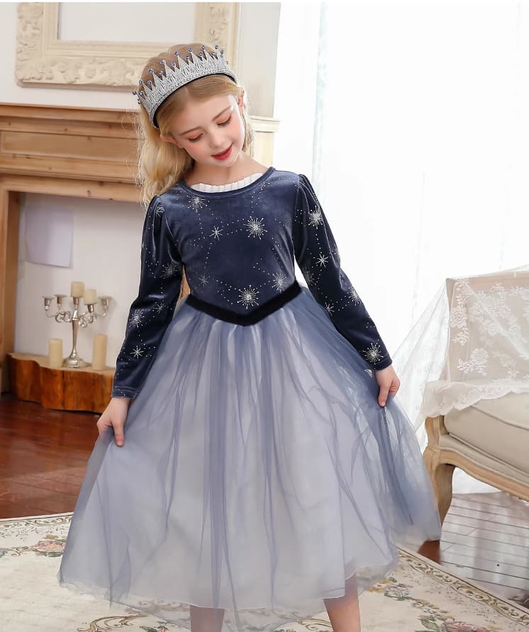 Young girl in a blue dress with star patterns Dark Blue Long Sleeves Sparkle snow queen Princess Dress  and a tiara in a decorated room.
