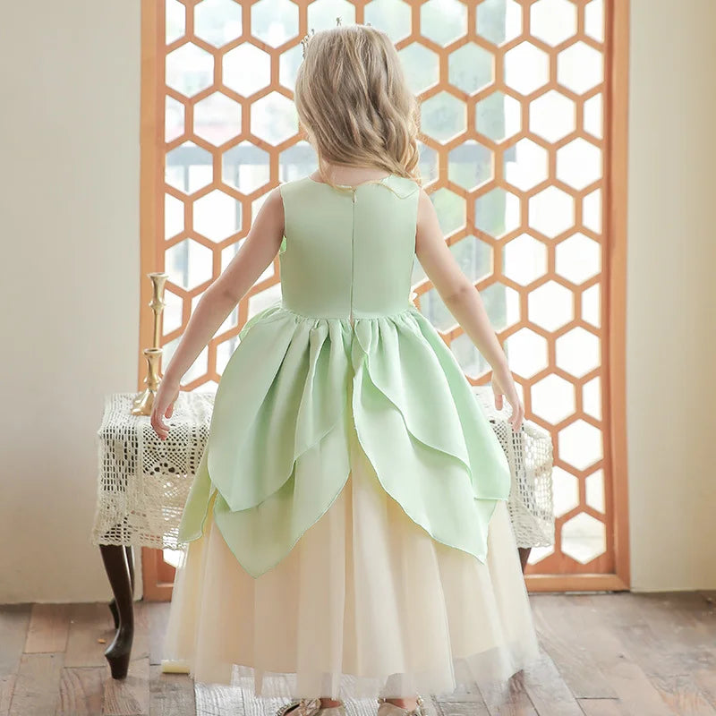 Young girl in a light green and white Green frog princess Dress  standing in front of a decorative screen.