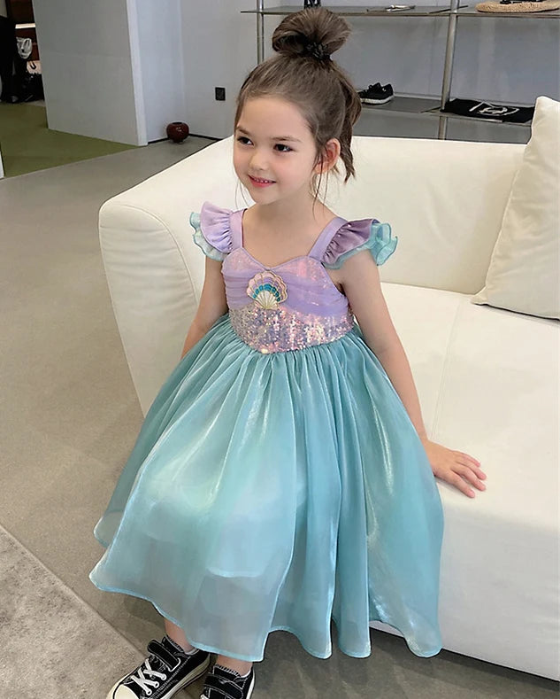 Young girl in a Green Purple Sequins Sleeveless Mermaid Princess Dress  sitting on a white couch.