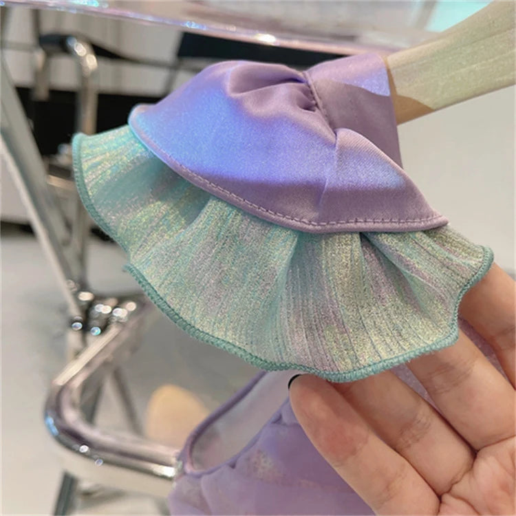 Multicolored fabric with a decorative edge held by a hand against a blurred background