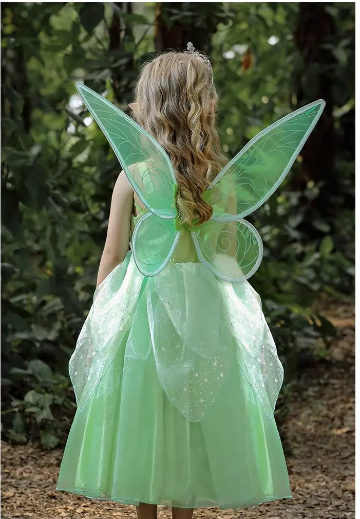 Child wearing a green fairy costume with wings in a forest setting