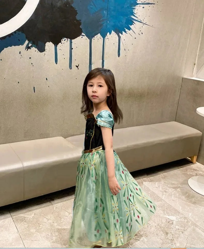 Young girl in a Green Tulle Ice Princess Costume dress standing in a modern interior setting with abstract wall art.