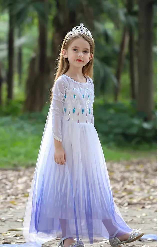Young girl in a Kids Blue and White Ice Queen Princess Sequin Dress With Cape  and a tiara standing outdoors.