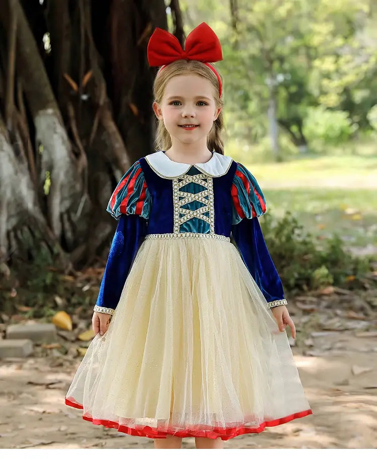Child in Snow White costume with red bow outdoors