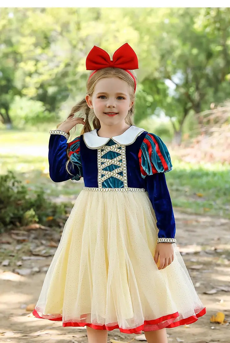 Child wearing a Snow White costume outdoors with greenery in the background