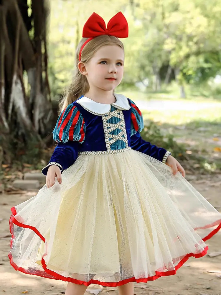 Child in Snow White costume with red bow outdoors