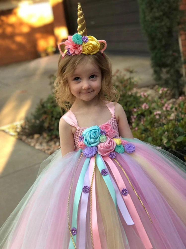 Young girl in a colorful unicorn-themed dress with flowers and a headband.