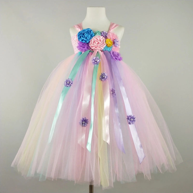 Pastel-colored dress with floral and ribbon details on a mannequin against a plain background