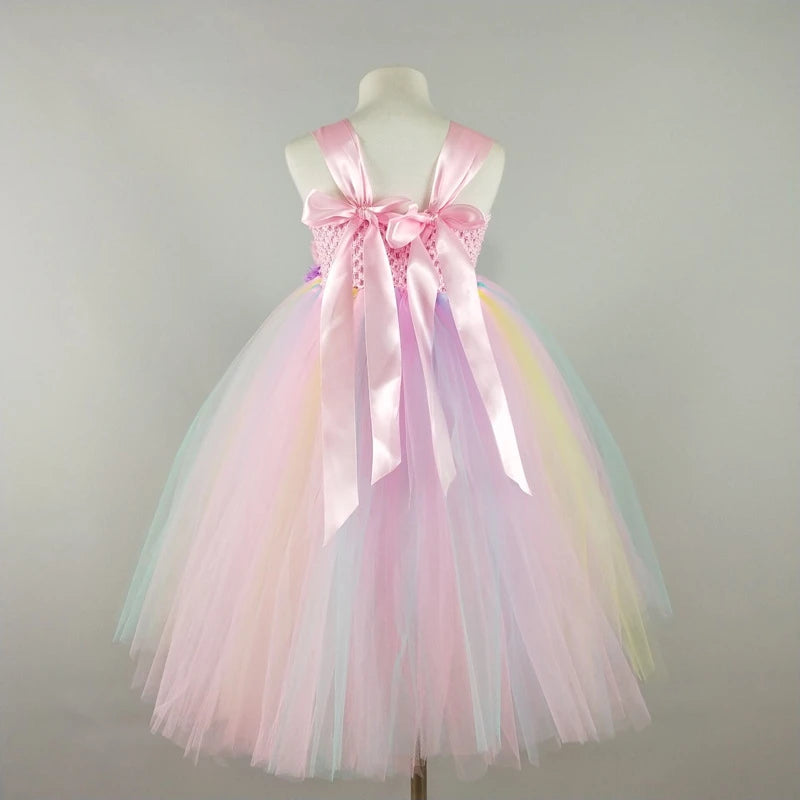 Pastel-colored tulle dress with a large bow on a mannequin against a gray background