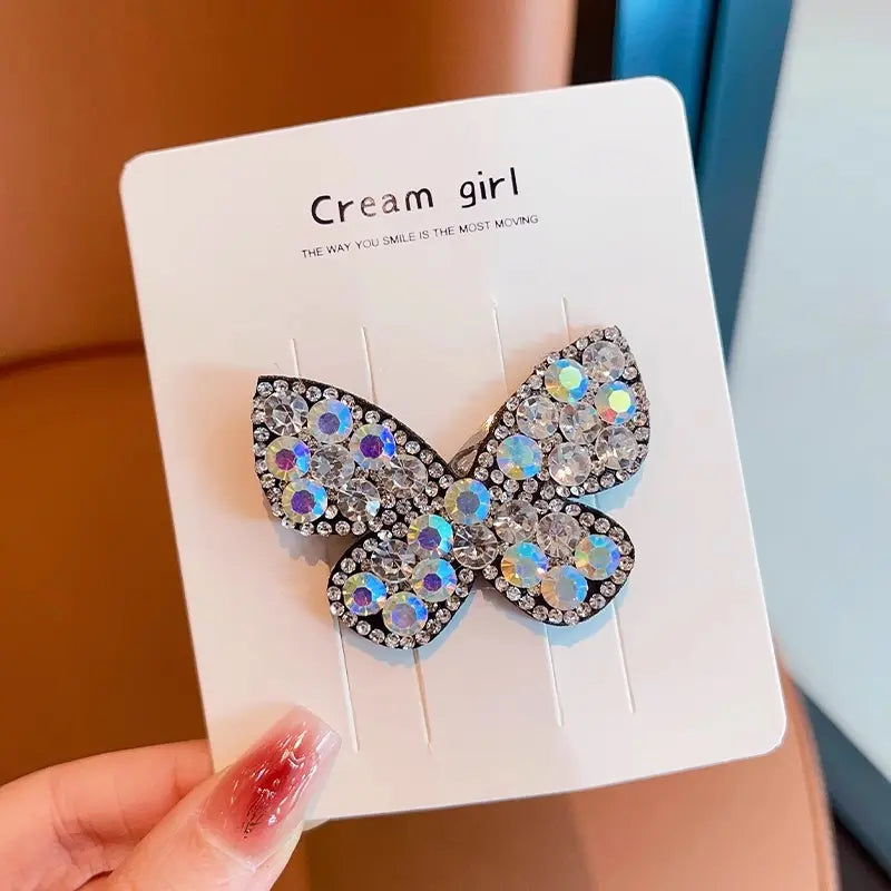 Butterfly-shaped hair clip with rhinestones on a card.