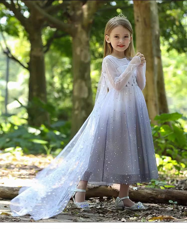 Young girl in a  Sparkling snow Queen Inspired Princess Dress With Cape with a long train standing in a forest.