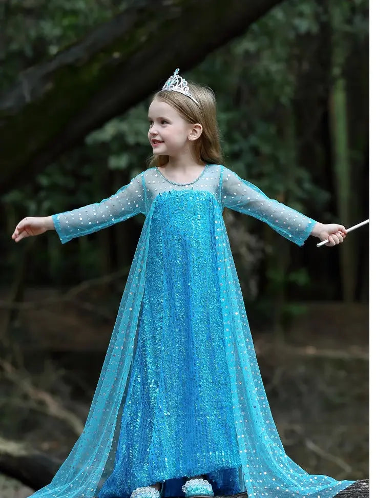 Child in a Sparkling Ice Queen Blue Sequin Gown with Sheer Cape with a tiara outdoors