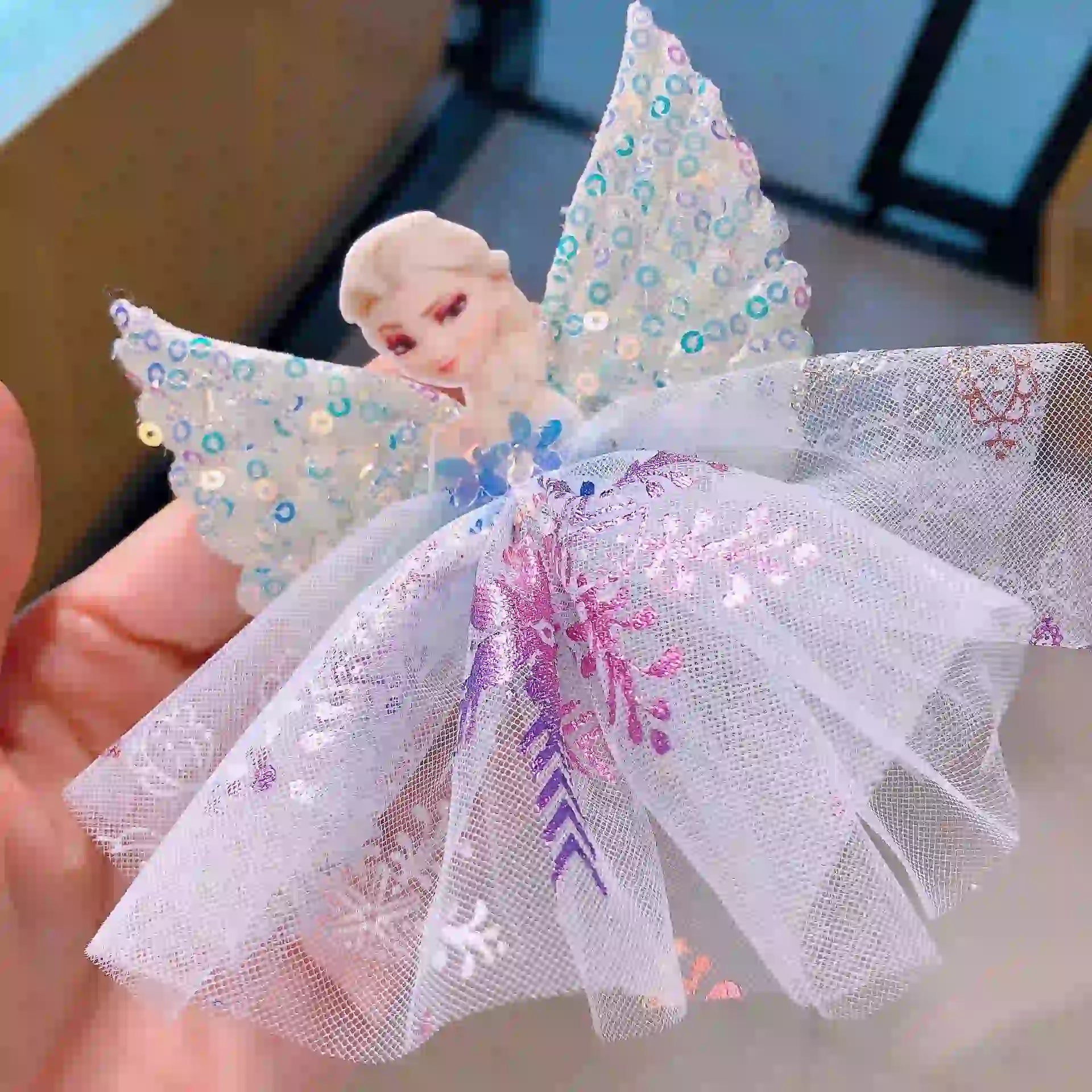 Sparkling Sequin Snow Queen elsa Hair Clip held by a hand.
