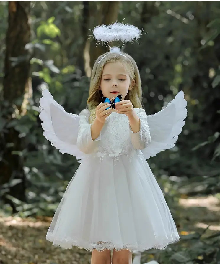 Young girl in an angel costume with wings and a halo outdoors.