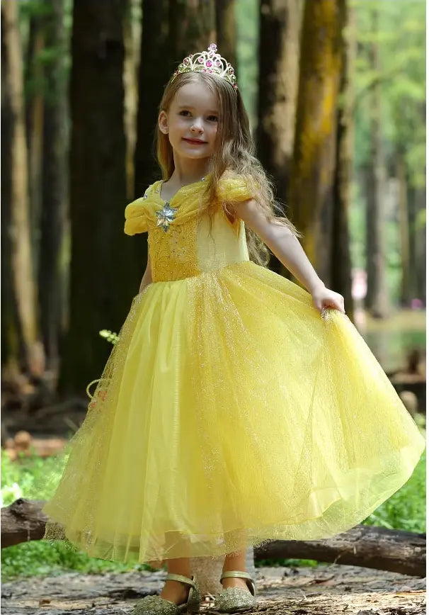 Young girl in a Yellow Tulle Princess Tulle Ball Gown Dress   with a tiara standing in a forest.