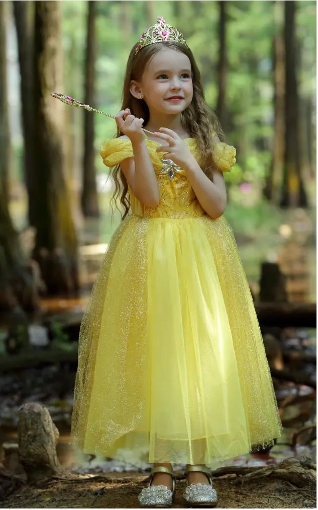 Young girl in a Yellow Tulle Princess Tulle Ball Gown Dress   with a tiara standing in a forest.