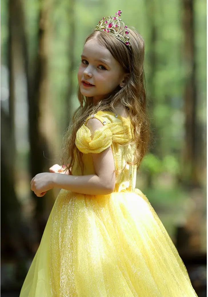 Young girl in a Yellow Tulle Princess Tulle Ball Gown Dress   with a tiara standing in a forest.