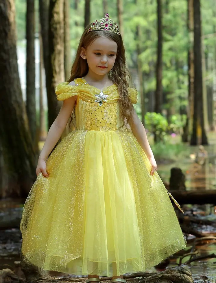 Young girl in a Yellow Tulle Princess Tulle Ball Gown Dress  with a tiara standing in a forest.