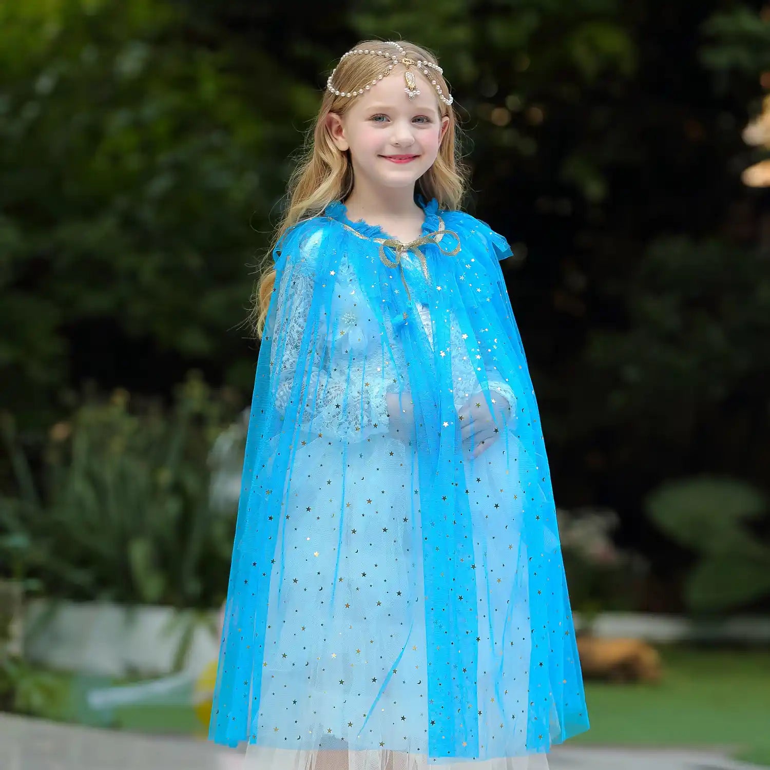 Young girl in a blue cape with star patterns outdoors