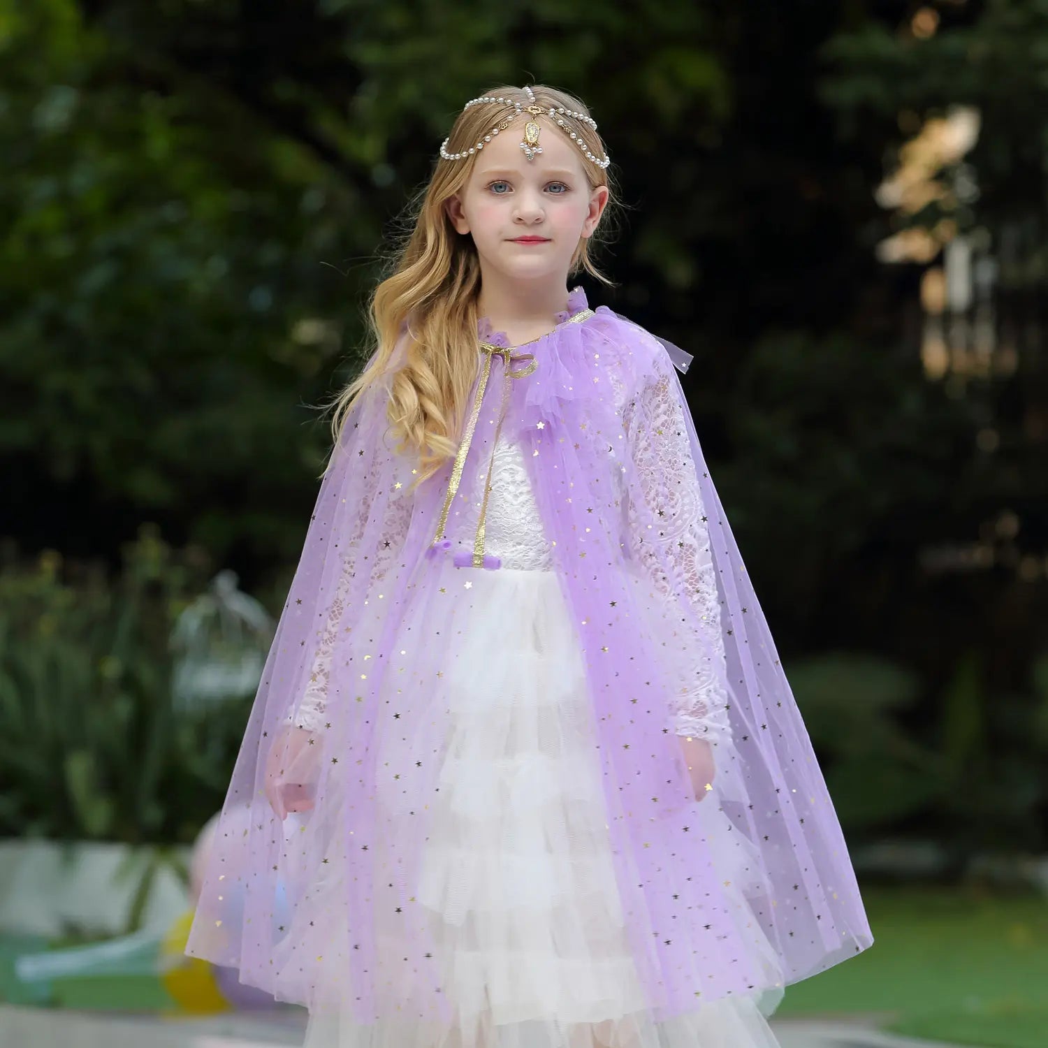 Young girl in a purple Star Tulle Fairy Dress Up Princess Cape  and white dress outdoors.